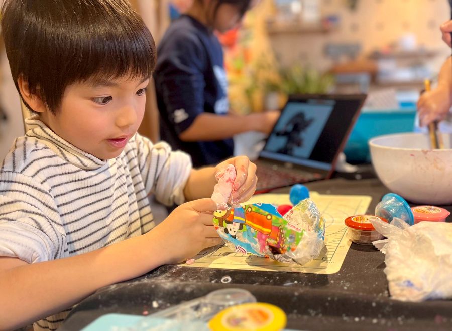 袖を捲り上げて、一生懸命作品を作っている男の子